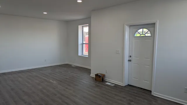 an empty room with windows and wooden floor