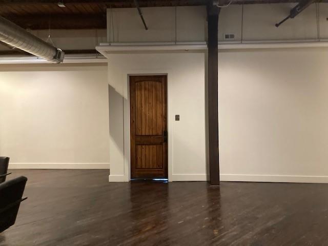 a view of an empty room with wooden floor and closet