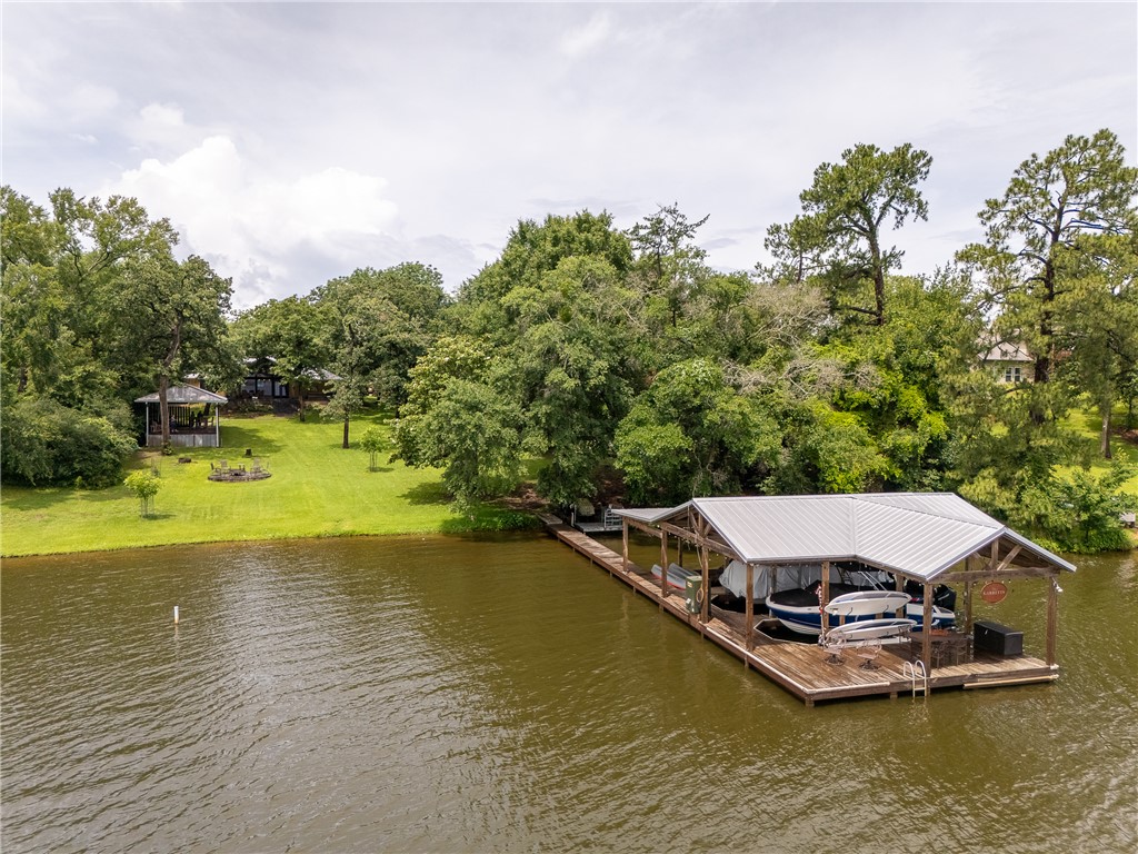 8695 Clyde Acord Road Franklin, TX 77856 - Photo 49 of 50 Dock area featuring boat lift, a water view, a lawn, and view of wooded area