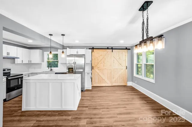 a kitchen with stainless steel appliances granite countertop a sink a stove and a refrigerator