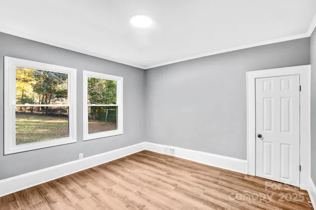 a view of empty room with wooden floor