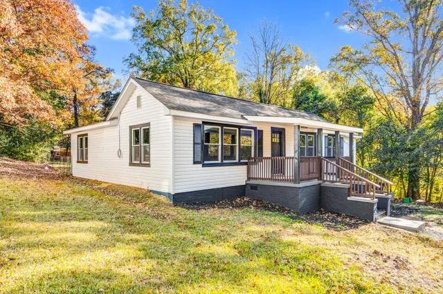 a front view of a house with a yard covered with snow and trees