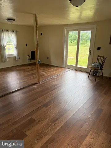 a view of a room with wooden floor and a window