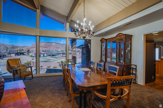 980 Cactus Circle St. George, UT 84790 - Photo 5 of 77 Dining room with a mountain view, dark colored carpet, a chandelier, and lofted ceiling with beams