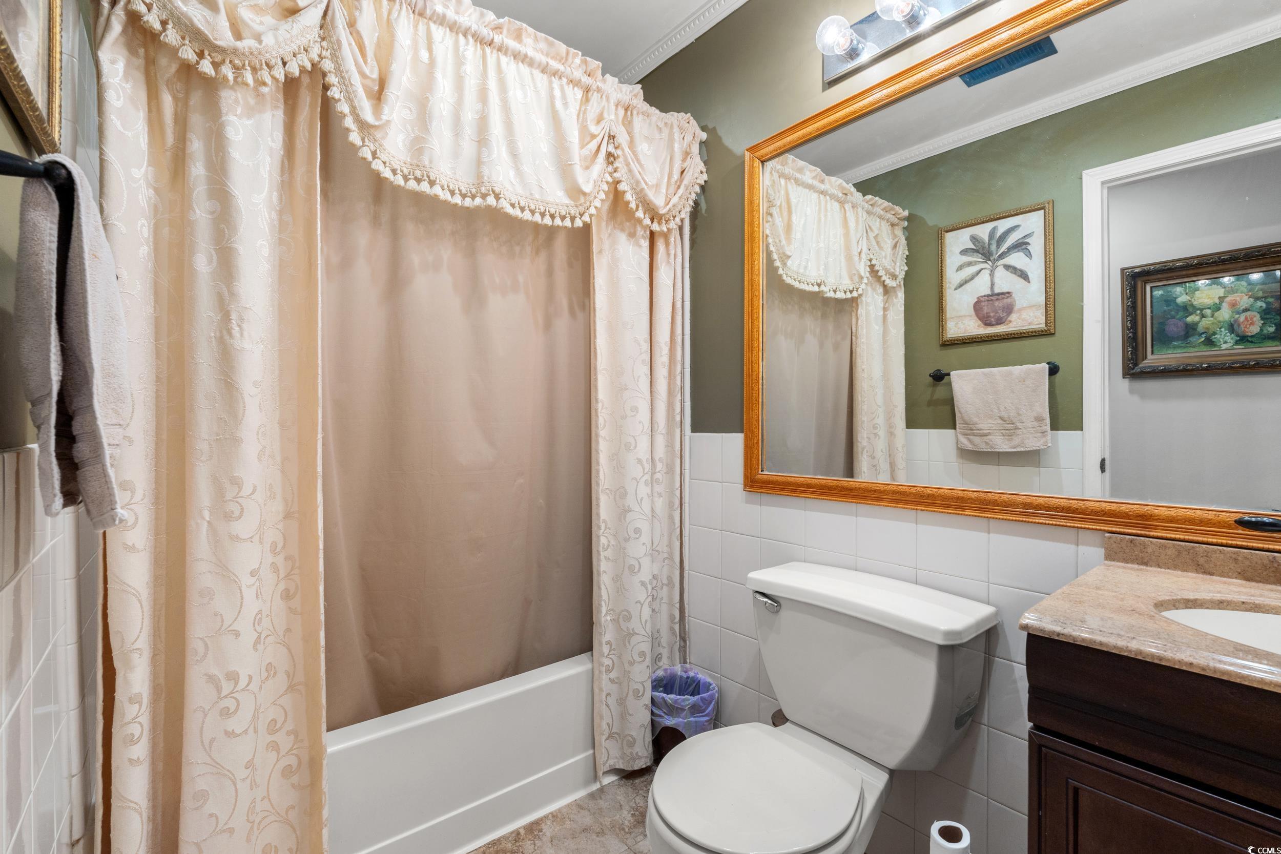 1141 Bethel Road Latta, SC 29565 - Photo 13 of 27 Full bath with shower / bath combination with curtain, vanity, tile walls, crown molding, and wainscoting