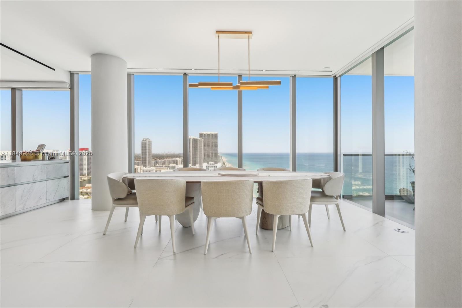 2000 South Ocean Drive, Unit 28A Hallandale Beach, FL 33009 - Photo 11 of 66 a dining room with furniture a chandelier and a floor to ceiling window