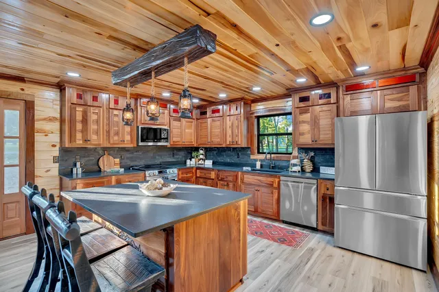 a view of an empty room with wooden floor and a fireplace