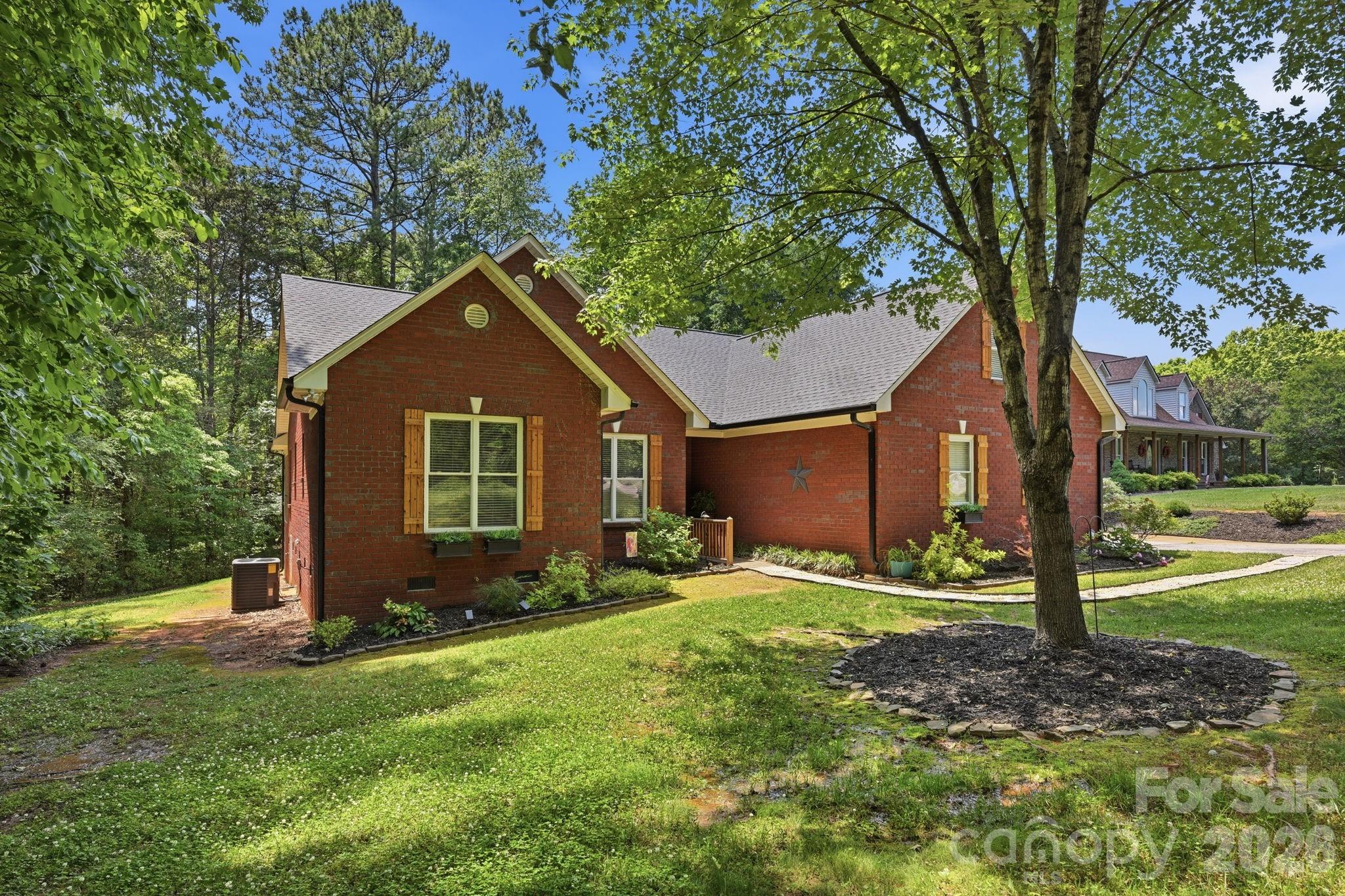 145 Upper Spencer Mountain Road Stanley, NC 28164 - Photo 3 of 29 a front view of a house with garden