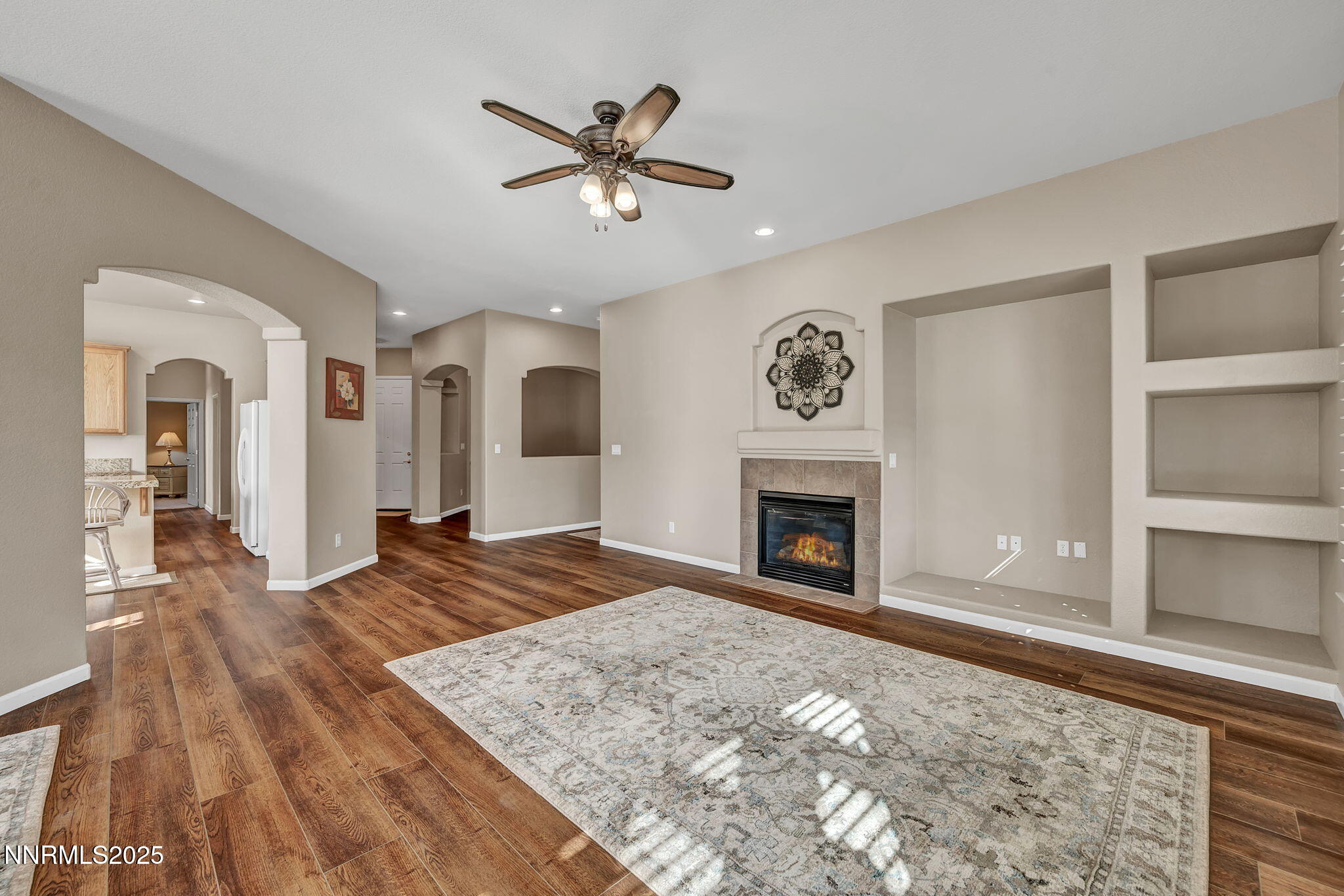 823 Gullane Court Dayton, NV 89403 - Photo 17 of 60 a view of a livingroom with a fireplace a ceiling fan and wooden floor