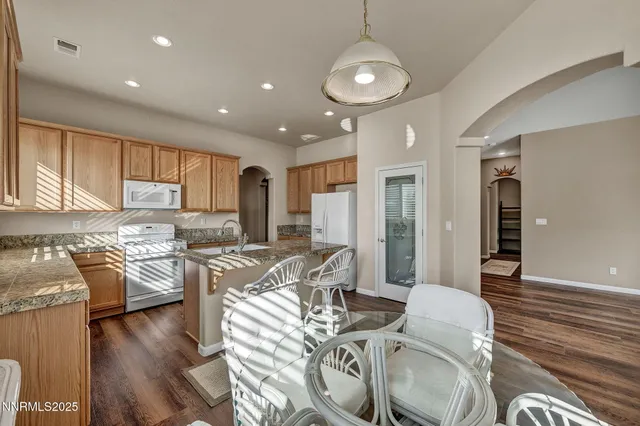 a kitchen with granite countertop kitchen island wooden cabinets a sink and a window
