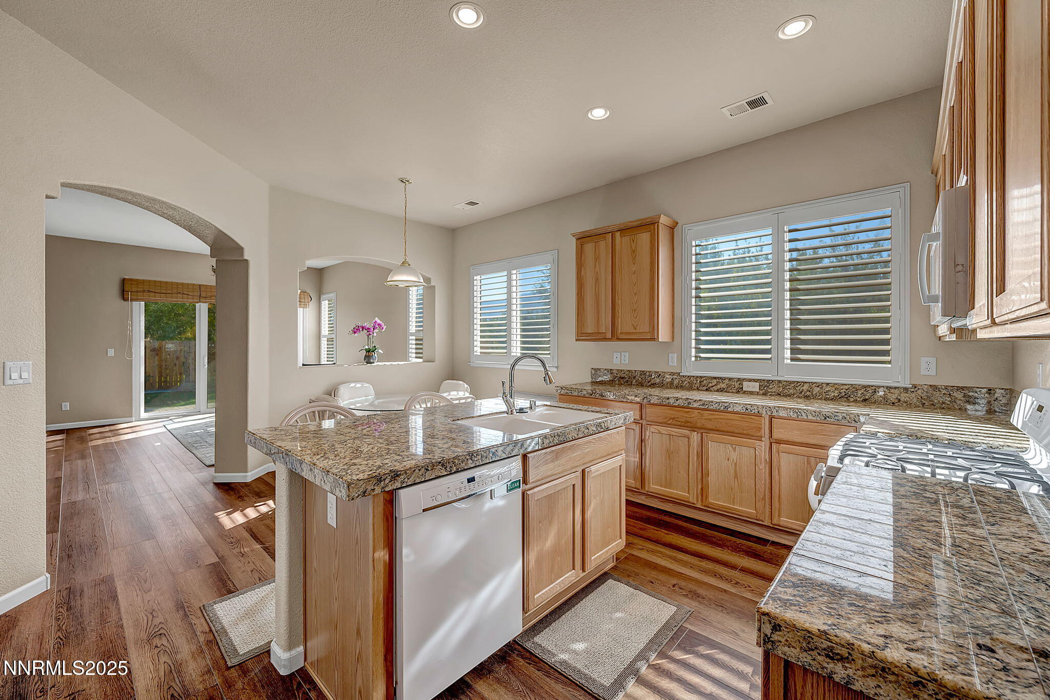 823 Gullane Court Dayton, NV 89403 - Photo 6 of 60 a kitchen with granite countertop kitchen island wooden cabinets a sink and a window
