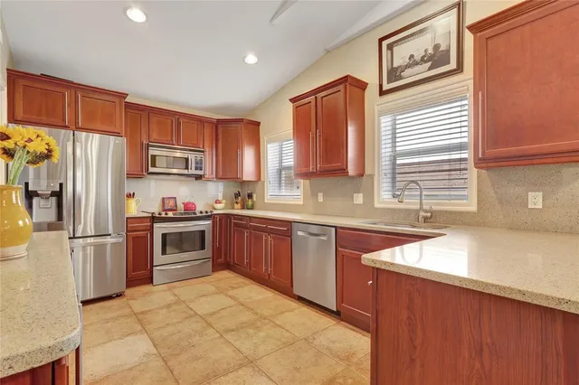 a kitchen with granite countertop a refrigerator stove top oven and sink