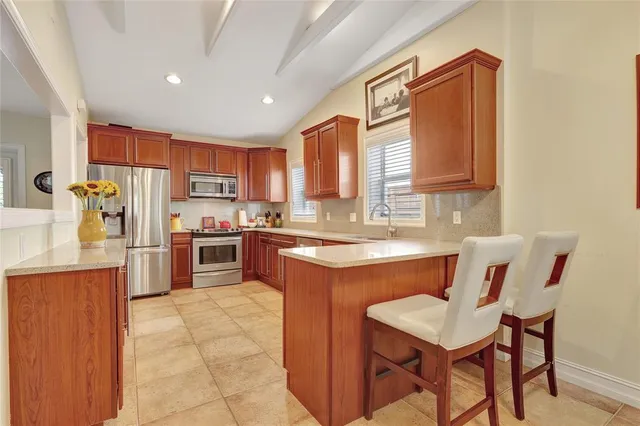 a kitchen with a refrigerator a stove a sink dishwasher with a dining table and chairs