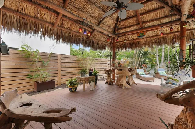 a view of a patio with table and chairs and potted plants with wooden floor