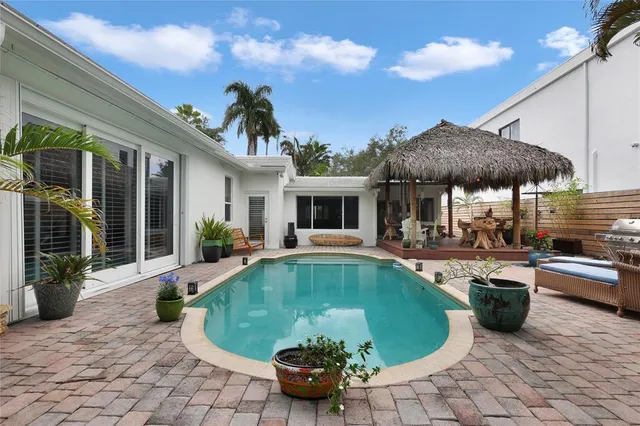a view of a house with swimming pool and sitting area