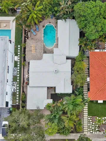 an aerial view of a house with a yard and a large tree