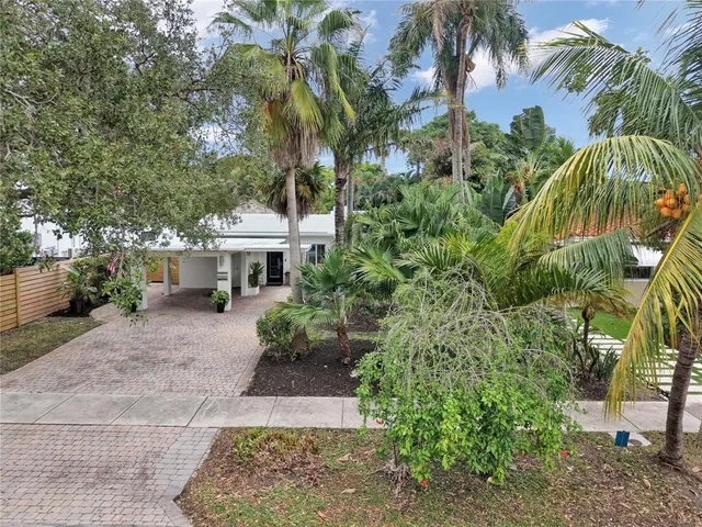 a front view of a house with a yard and a garden