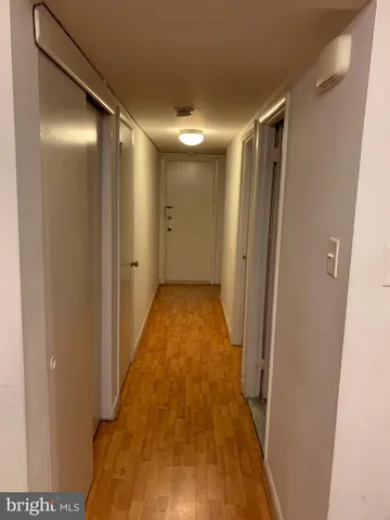 a view of hallway with stainless steel appliances wooden floor and staircase