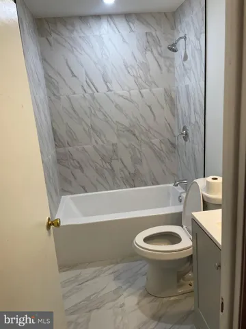 a white toilet sitting next to a bath tub