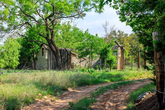 a backyard of a house with lots of green space and fountain