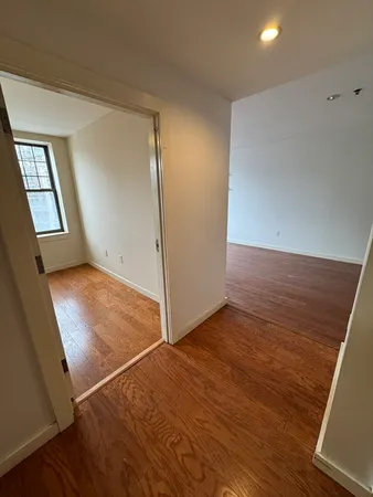 an empty room with wooden floor and mirror