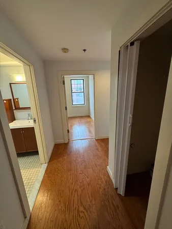 a view of a hallway with wooden floor and stairs