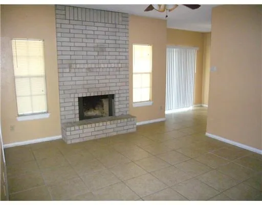 a view of an empty room with a fireplace and a window