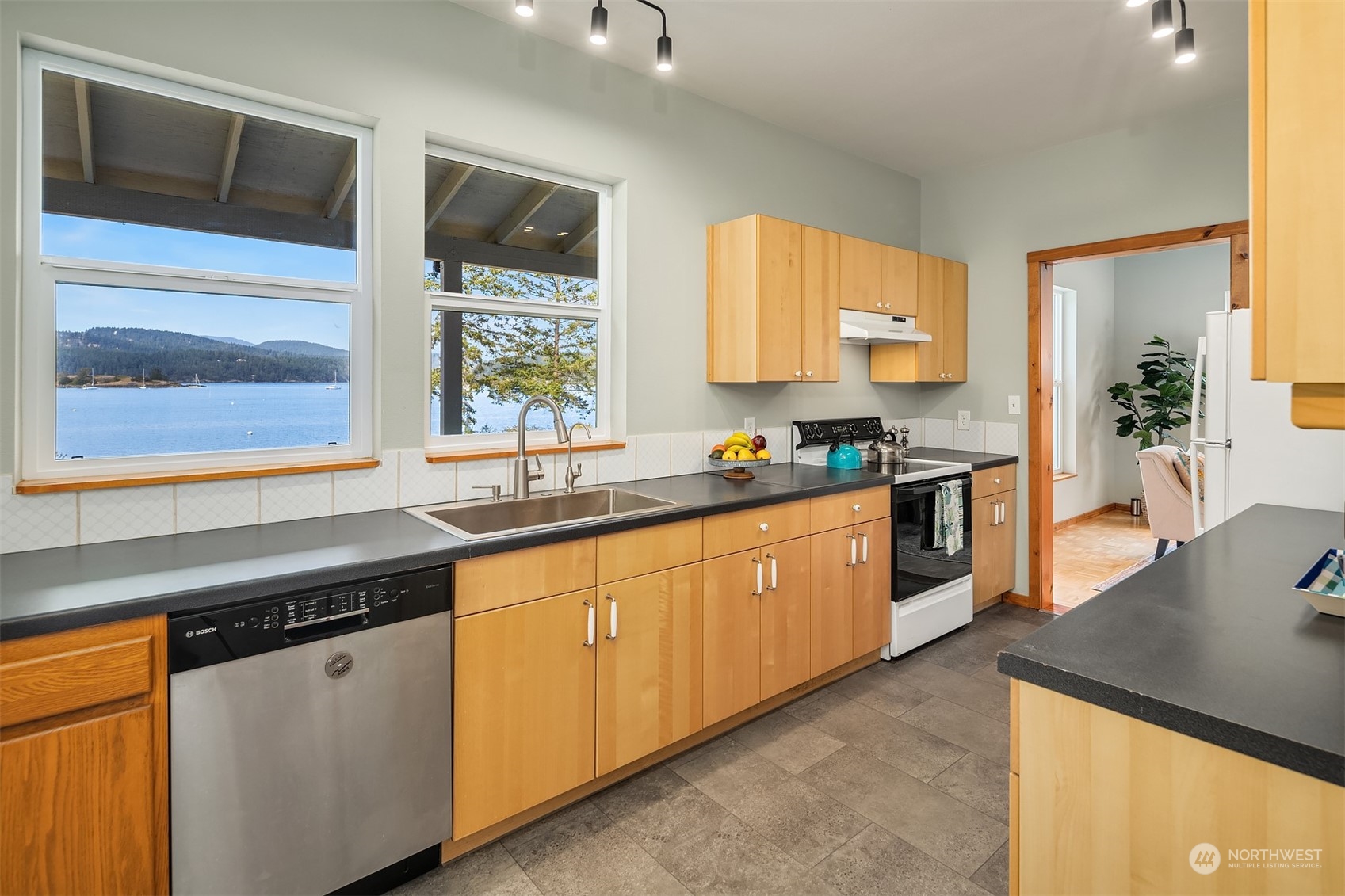 378 Smugglers Cove Road Shaw Island, WA 98286 - Photo 28 of 40 a kitchen with stainless steel appliances granite countertop white cabinets and window
