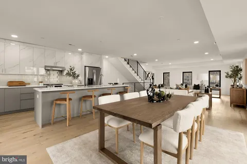a kitchen with a dining table chairs and wooden floor