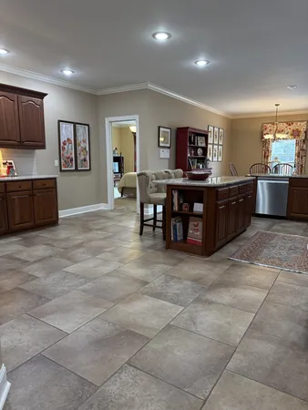 a living room with stainless steel appliances furniture a kitchen island a stove top oven a sink a dining table and chairs