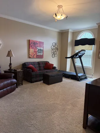 a living room with furniture a window and a flat screen tv