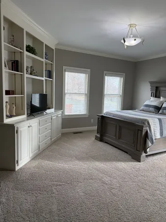 a spacious bedroom with a bed and a window