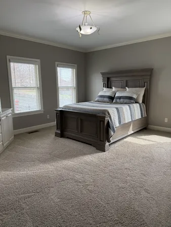 a spacious bedroom with a bed and a window