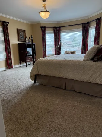a bedroom with a bed and dresser with mirror