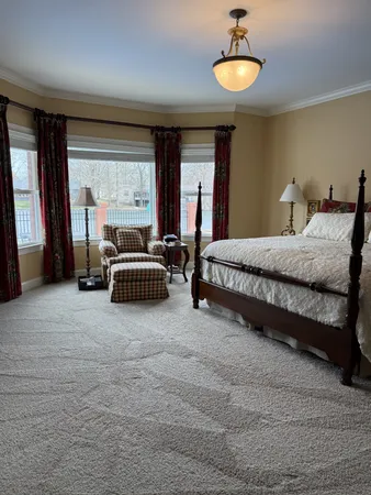a spacious bedroom with a bed and a large window