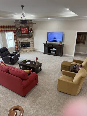 a living room with furniture a flat screen tv and a fireplace