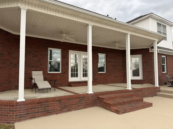 a view of swimming pool with lawn chairs and iron fence