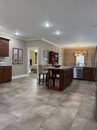 a view of kitchen with kitchen island microwave and cabinets