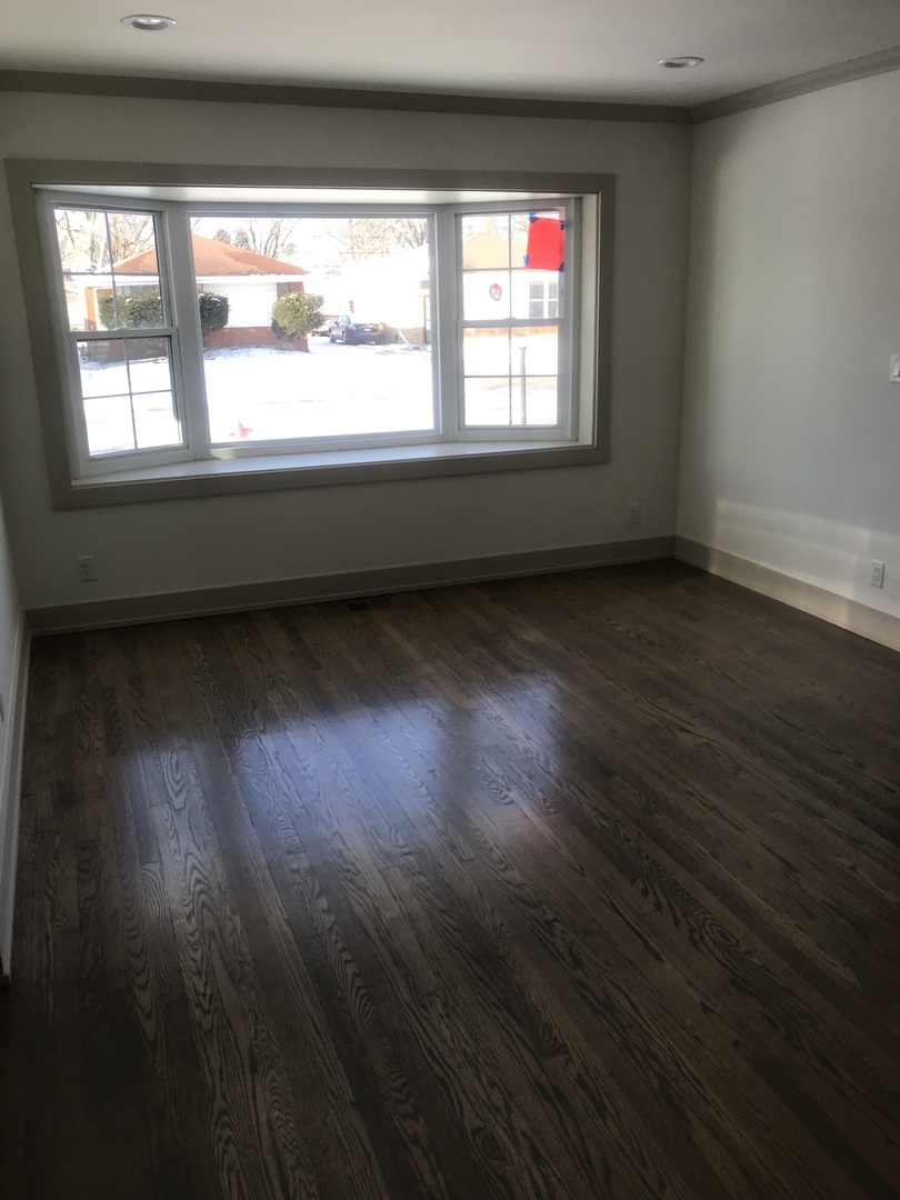 149 Rice Avenue Bellwood, IL 60104 - Photo 6 of 13 an empty room with wooden floor and windows