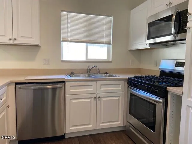 a kitchen with granite countertop cabinets stainless steel appliances and wooden floor