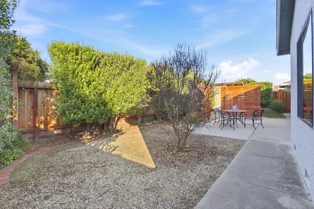a backyard of a house with table and chairs