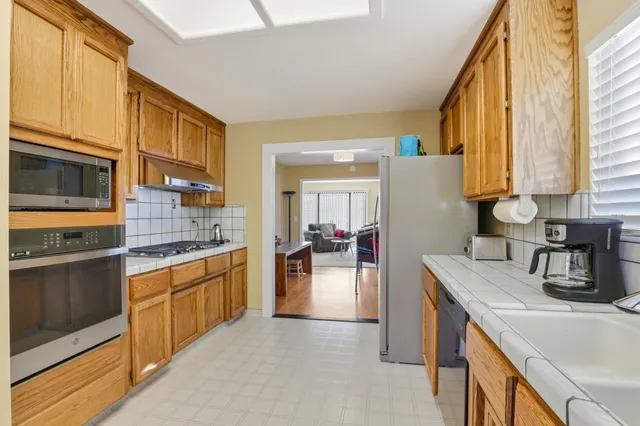 a kitchen with granite countertop a sink stove and cabinets