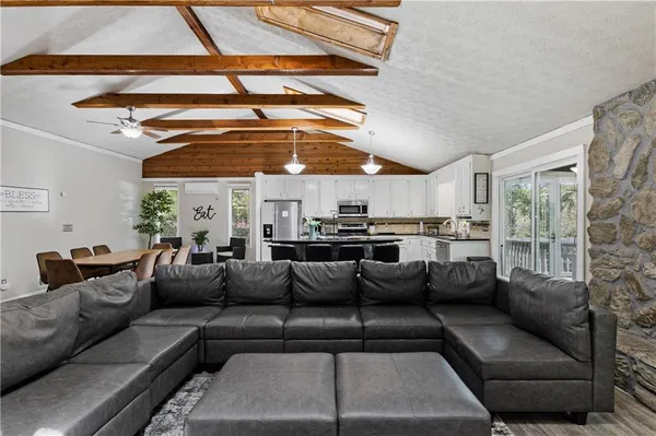 a kitchen with stainless steel appliances a stove a sink refrigerator and a chair