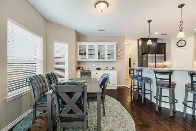 a kitchen with stainless steel appliances granite countertop a stove top oven a sink dishwasher and a refrigerator with wooden cabinets