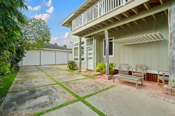 a view of an house with backyard outdoor seating area and garden