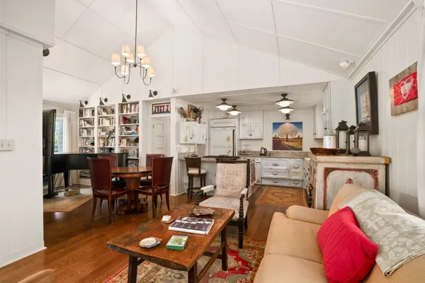 a living room with furniture a dining table and a chandelier