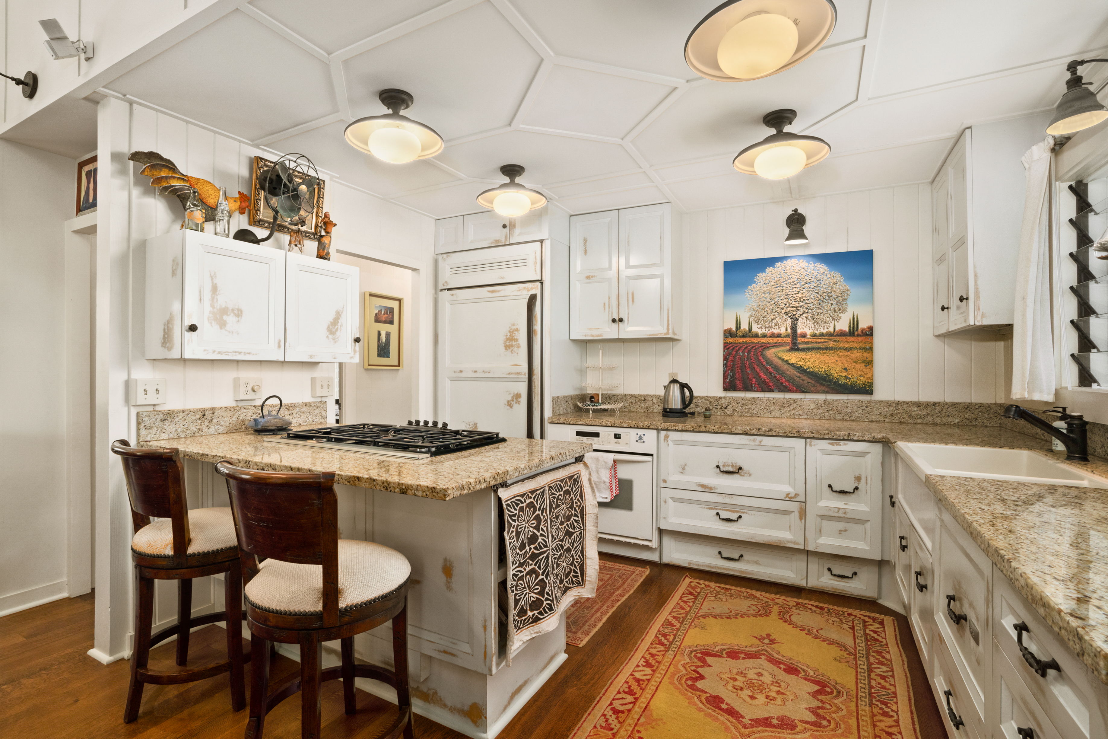 5225 Ua Road Kapaa, HI 96746 - Photo 6 of 30 a kitchen with granite countertop a sink stove and white cabinets with wooden floor