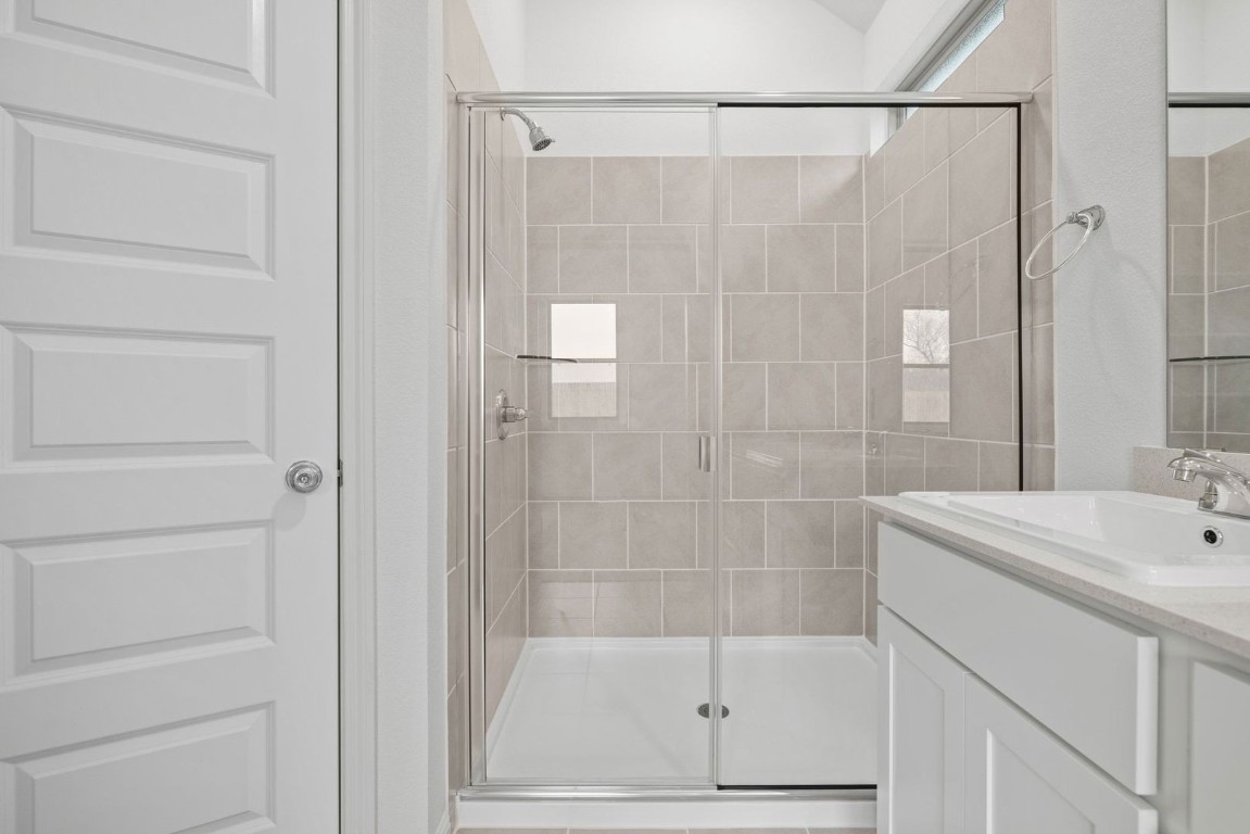 1249 Minorca Street Huffman, TX 77336 - Photo 15 of 25 a bathroom with a shower a sink and a mirror