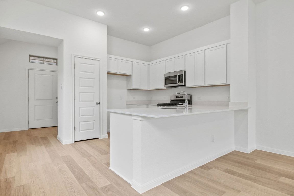 1249 Minorca Street Huffman, TX 77336 - Photo 6 of 25 a kitchen with stainless steel appliances granite countertop a refrigerator sink and white cabinets