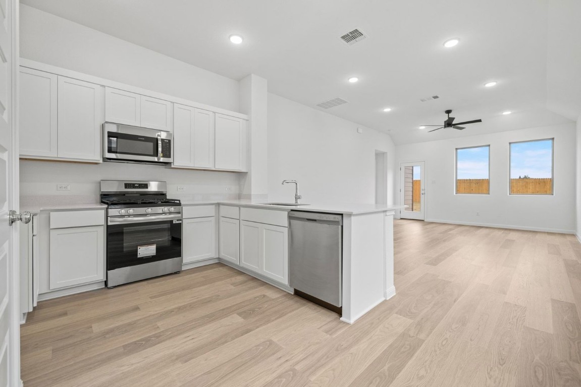 1249 Minorca Street Huffman, TX 77336 - Photo 7 of 25 a kitchen with granite countertop a stove top oven and cabinets
